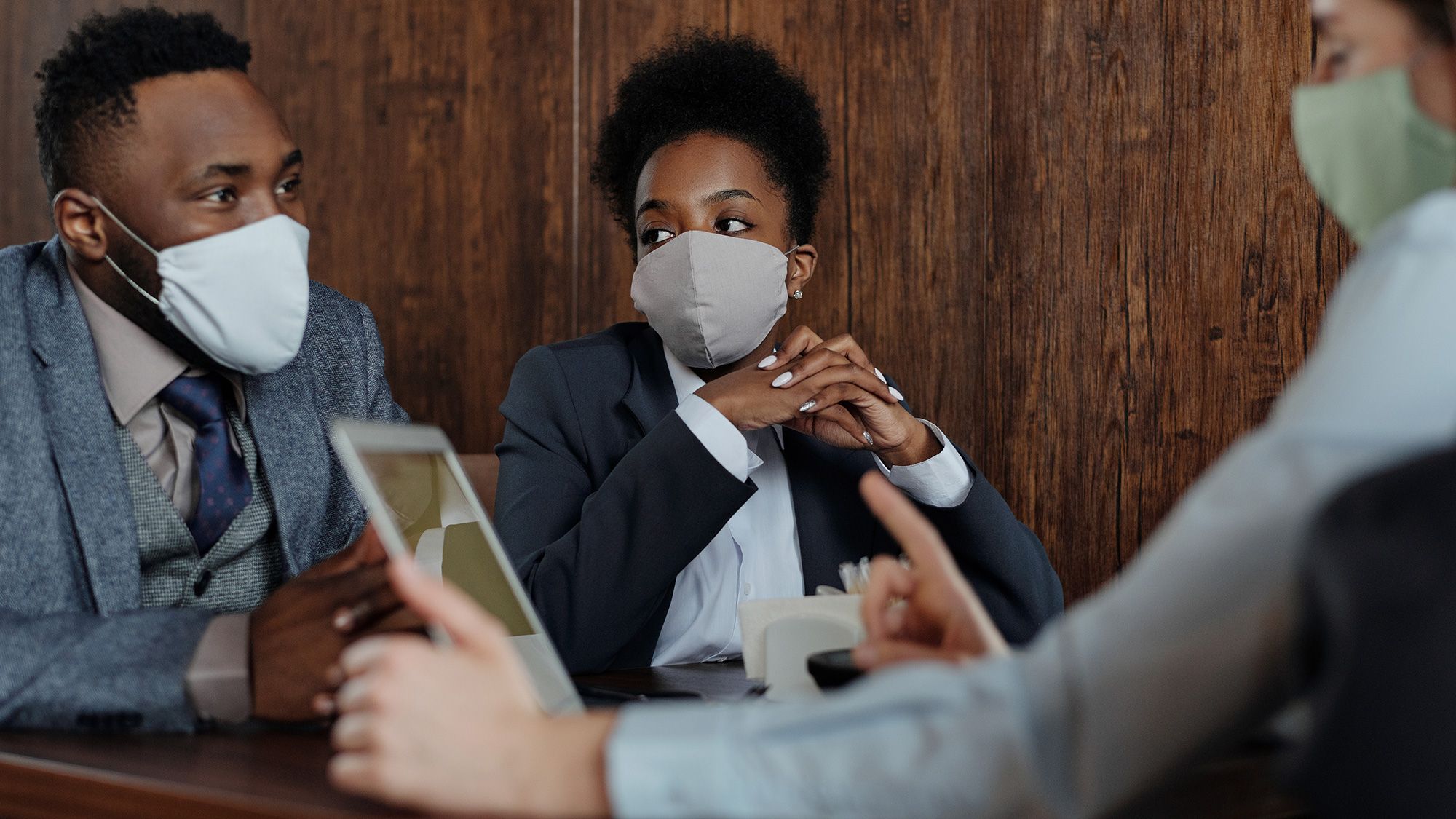 Business owners, wearing facemasks, talking to a UKSE advisor about a Corporate PPA